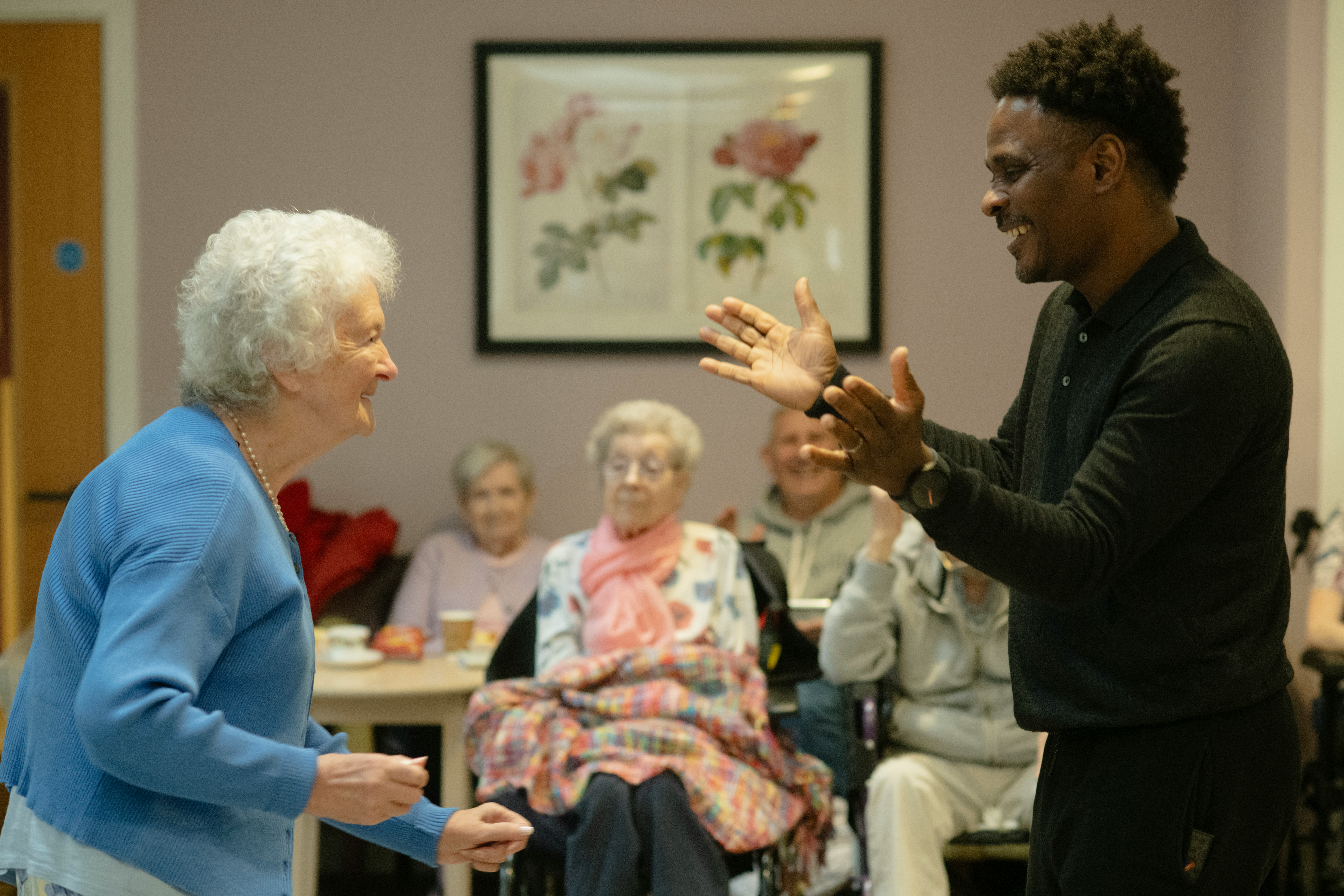 Caregiver interacting warmly with senior client at home